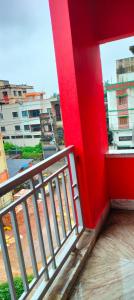 a balcony with a red wall and a red railing at Howrah Homestay Nidhivan in Howrah