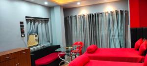 a red bedroom with a red couch and a table at Howrah Homestay Nidhivan in Howrah