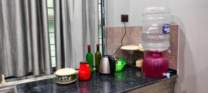 a counter top with bottles and a water container on it at Howrah Homestay Nidhivan in Howrah +16 photos