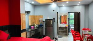 a kitchen with red chairs and a counter top at Howrah Homestay Nidhivan in Howrah