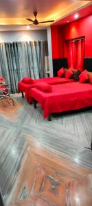 two beds in a room with red walls at Howrah Homestay Nidhivan in Howrah
