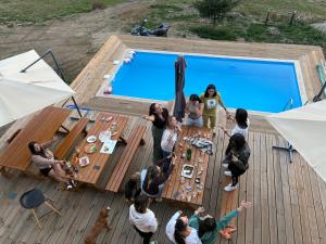 a group of people standing around a table next to a swimming pool at Gorska vila Vasilija in Ivanjica
