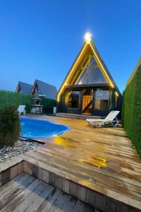 a house with a wooden deck and a swimming pool at Altınkum Bungalov in Dereköy