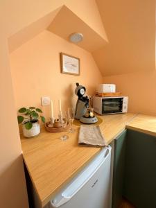 a small kitchen with a counter top with a microwave at Studio LS - Plage, falaise, Funiculaire, in Le Tréport +13 photos