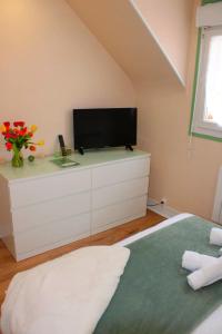 a bedroom with a tv on top of a dresser at Studio LS - Plage, falaise, Funiculaire, in Le Tréport