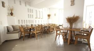 a dining room with wooden tables and chairs at Harmony Hotel in Sarandë