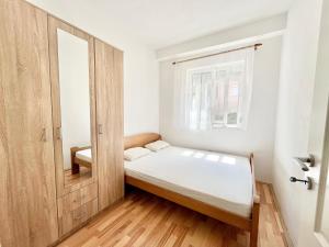 a small bedroom with a bed and a window at B&V apartmani in Šušanj