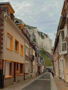 an empty street with buildings and a mountain in the background at Studio LS - Plage, falaise, Funiculaire, in Le Tréport