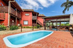 a swimming pool in front of a house at Beautiful Pousada in the middle of nature in Bombinhas in Canto Grande