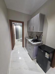 a small kitchen with a sink and a stove at جلنار الشرق للشقق المخدومة in Jeddah
