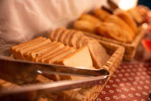 a tray ofasted bread on a table with baskets of bread at Pousada Locomotiva 206 in Conservatória