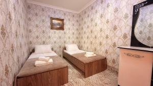 a small room with two beds and a mirror at Private 3BR House 2 Min Walk to Registan in Samarkand