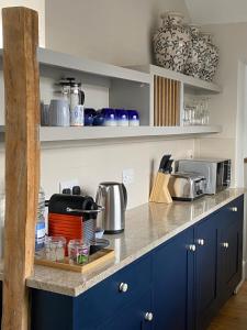 a kitchen with blue cabinets and a counter top at Hidden Gem - Charmouth Dorset in Charmouth