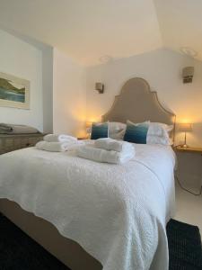 a bedroom with a white bed with towels on it at Hidden Gem - Charmouth Dorset in Charmouth