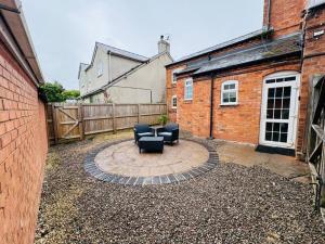 a patio with two chairs and a table and a fence at sinton House in Bransford