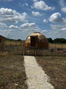 a yurt in a field next to a fence at Dôme géodésique in Brie
