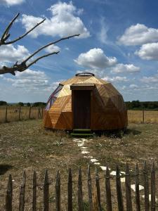 a yurt in a field next to a fence at Dôme géodésique in Brie