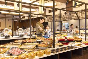 a woman and a child standing in a buffet at Ooedo Onsen Monogatari Premium Enakyo in Ena