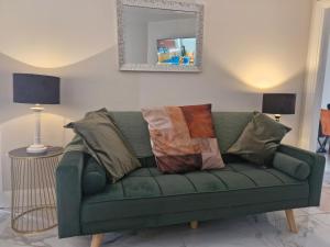 a green couch with pillows in a living room at Bellmullet, Waterside Townhouse in Belmullet