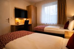 ein Hotelzimmer mit zwei Betten und einem Fenster in der Unterkunft Hotel Stadion Stadt in Hamburg