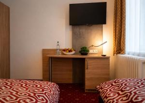 ein Hotelzimmer mit einem Tisch, auf dem eine Obstschale steht in der Unterkunft Hotel Stadion Stadt in Hamburg + 6 Fotos