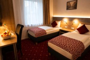 ein Hotelzimmer mit zwei Betten und einer Obstschale in der Unterkunft Hotel Stadion Stadt in Hamburg