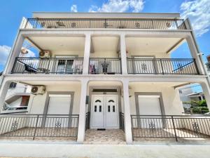 a large white house with balconies on it at B&V apartmani in Šušanj