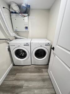 a laundry room with a washer and dryer in it at Purplecherry Haven in Regina