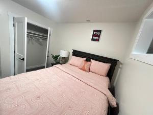 a bedroom with a large bed with pink sheets at Purplecherry Haven in Regina +7 photos