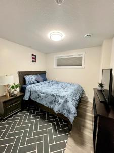a bedroom with a bed and a flat screen tv at Purplecherry Haven in Regina