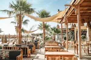a restaurant with tables and chairs and palm trees at Jacksons sea view living in Kos