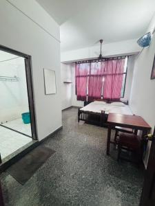 a room with a bed and a table and a window at Panchavadi Beach Resort in Varkala +13 photos