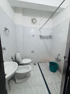 a white bathroom with a toilet and a sink at Panchavadi Beach Resort in Varkala