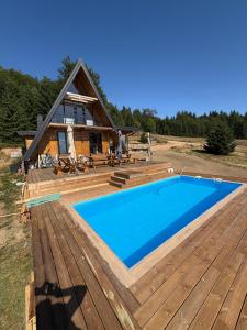 a house with a large swimming pool on a wooden deck at Gorska vila Vasilija in Ivanjica