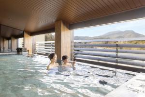 a woman and child in a hot tub at Ooedo Onsen Monogatari Premium Enakyo in Ena