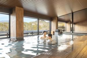 a woman and child swimming in a swimming pool at Ooedo Onsen Monogatari Premium Enakyo in Ena