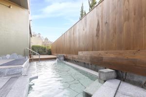 a swimming pool in a backyard with a wooden wall at Ooedo Onsen Monogatari Premium Enakyo in Ena +76 photos