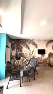 two chairs and a table in a room with a mural at Metroinn Hotel in Arau +38 photos