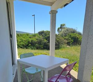 Ein Tisch und Stühle auf einer Veranda mit Aussicht in der Unterkunft Alma Bed & Breakfast 15 minuti da Bosa e comodo parcheggio in Sennariolo