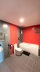 a bathroom with a toilet and a red wall at Metroinn Hotel in Arau