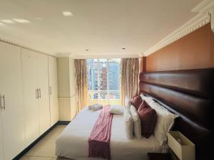 a bedroom with a large bed with a large window at The Sails-Luxe Penthouse By Ezey Tours in Durban +60 photos
