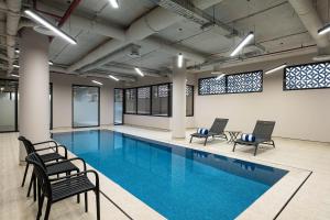a large swimming pool with chairs and chairs around it at Locanda Homes by Jareed لوكاندا هومز باي جريد in Riyadh