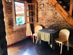 Ein Tisch und Stühle in einem Raum mit einer Backsteinwand in der Unterkunft Hotel Jasy in Puerto Iguazú