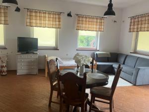 a living room with a table and a couch at Agroturystyka Nad Jeziorem Piecki in Piecki