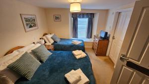 a small bedroom with two beds and a television at The Ship Inn Looe in Looe