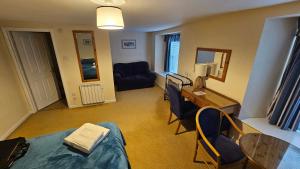 a room with a bed and a table and chairs at The Ship Inn Looe in Looe +2 photos