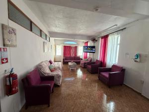 a living room with purple couches and a tv at Green Peak Stay in Port Louis