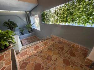 a room with a tile floor with plants and a window at Green Peak Stay in Port Louis