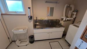 a small kitchen with a sink and a sink at Shimano Yado Rishirikuru in Rishiri