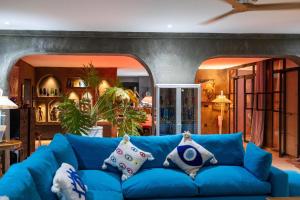 a blue couch with pillows in a living room at Casa Misasha, pool & rooftop-5 suites-13 lits-hamam in Essaouira